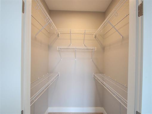 Empty white shelves in a pantry.
