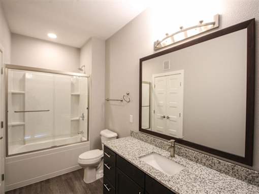 A bathroom with a sink, toilet, and shower.