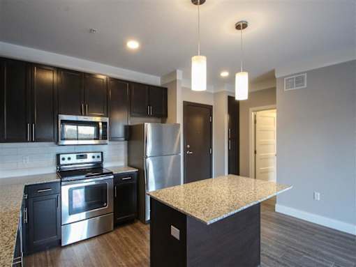 A kitchen with black cabinets and stainless steel appliances.