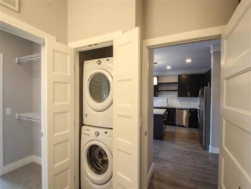 A white washing machine is in a small laundry room.