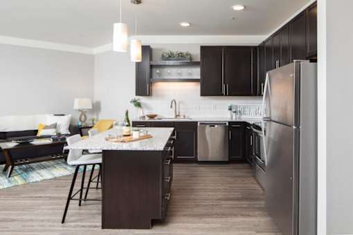 A modern kitchen with dark wood cabinets and a large island.