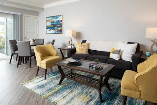 A living room with a grey couch, a yellow chair, and a coffee table.