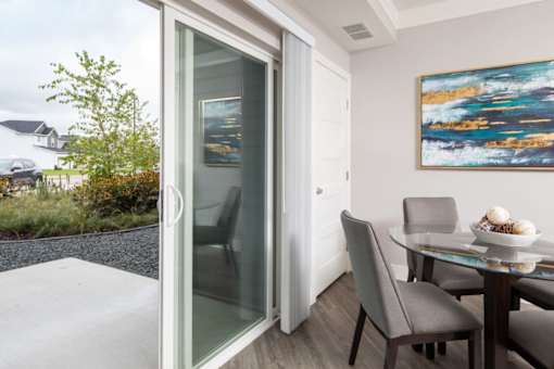 A modern dining room with a glass table and chairs.