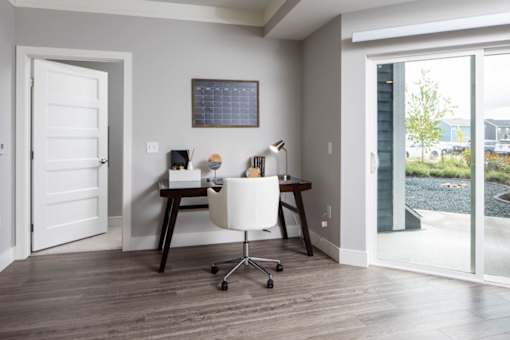 A room with a desk and a chair in it.