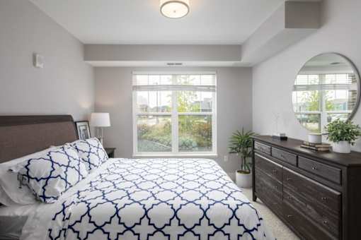 A bedroom with a large bed and a mirror on the wall.
