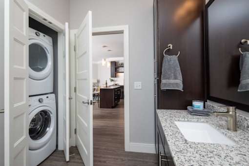 A white washing machine is in a small laundry room.