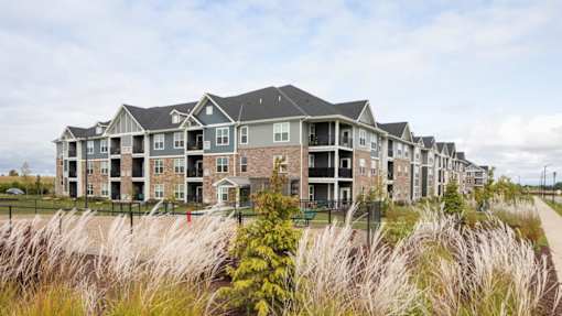 A row of houses with a grassy area in front.