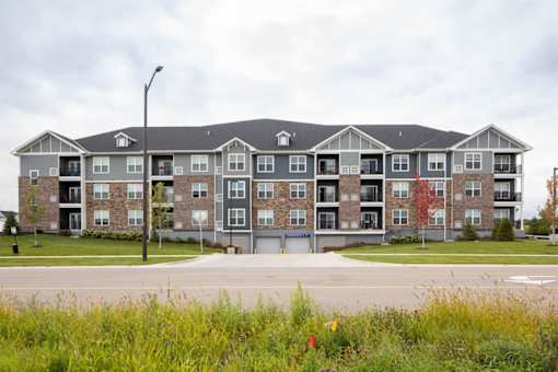 A large apartment complex with a grassy area in front.