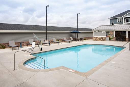 A small pool with a concrete floor and a metal railing.