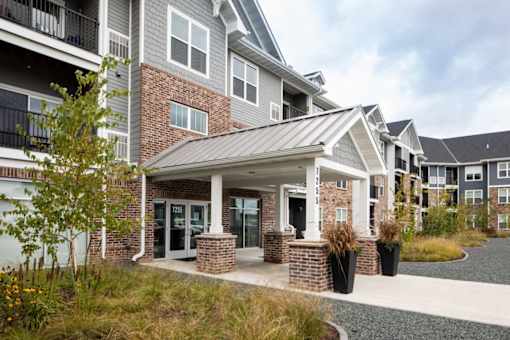 A modern building with a grey and white exterior and a covered walkway.