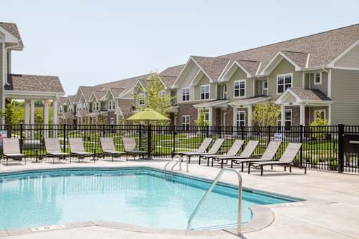 A pool surrounded by lounge chairs at The Edison at Rice Creek I and II, Shoreview