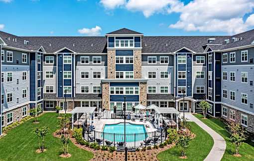 A large apartment complex with a pool in the middle of the courtyard at The Barnum Apartments, Minnesota