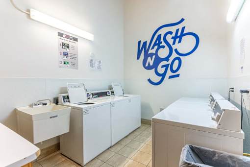 A laundromat with a blue wall graphic that says Wash 'n Go.