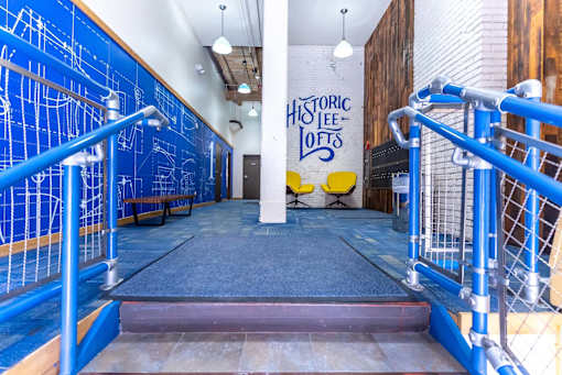 A blue railing with a white pole in the middle of a room.