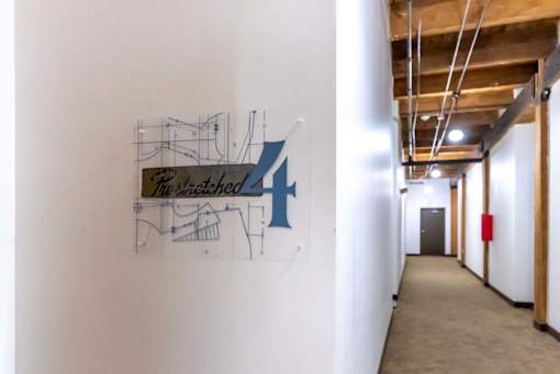 A hallway with a large blue and black artwork on the wall.