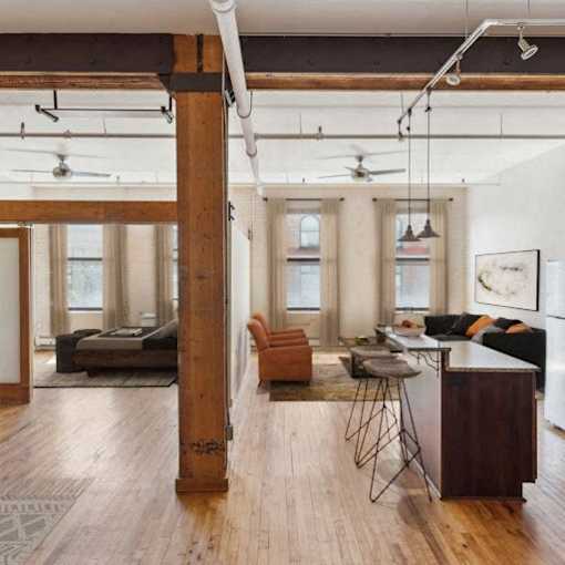 A living room with a brown floor and a white ceiling.