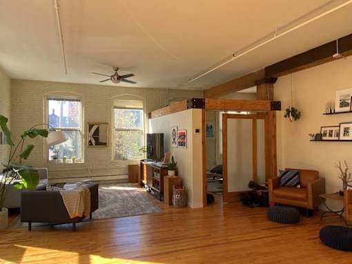 A living room with a wooden floor and a ceiling fan.