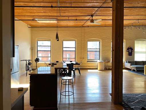 A kitchen with a bar stool and a table with chairs.