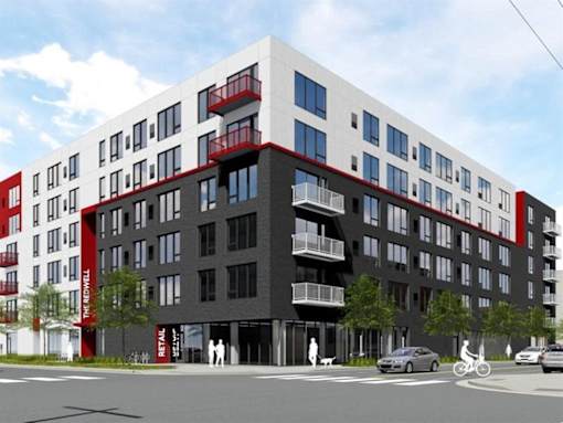 A modern multi-story building with a red and black facade and a sign at The Redwell Apartments, Minneapolis, 55401
