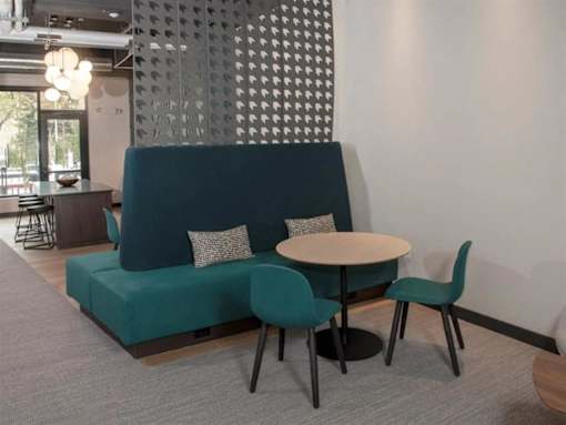 A modern living room with a green sofa, a round table, and a patterned wall at The Redwell Apartments, Minnesota 55401
