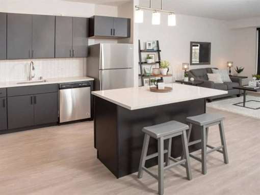 A kitchen with a bar stool in front of it at The Redwell Apartments, Minnesota