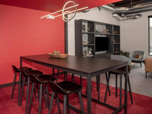 A modern dining area with a dark table and chairs at The Redwell Apartments, Minneapolis, 55401