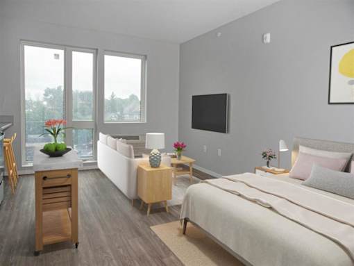 A bedroom with a large bed, a television, and a table with a vase of flowers on it.