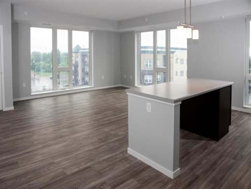 A large, empty room with a desk and a window overlooking a cityscape.