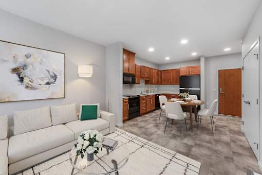 A modern living room with a white couch and a coffee table with flowers on it at Soul Apartments, St. Paul