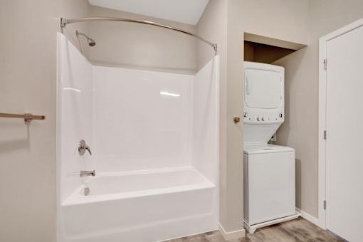 A white bathroom with a tub and a toilet at Soul Apartments, St. Paul, 55107