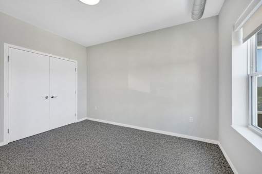 A room with a white door and grey carpet at Soul Apartments, St. Paul, 55107