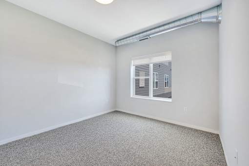 A room with a window and a grey carpet at Soul Apartments, St. Paul