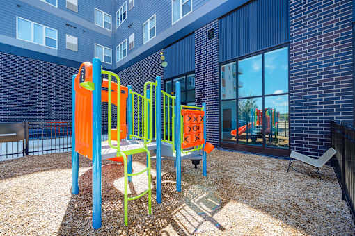 A playground with a slide, swings, and a climbing frame at Soul Apartments, Minnesota 55107