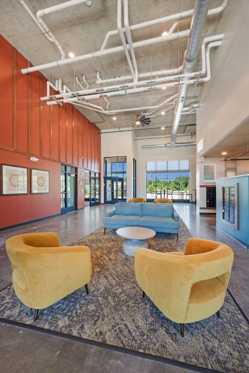 Two yellow chairs are on a rug in a room with a blue couch at Soul Apartments, St. Paul, Minnesota