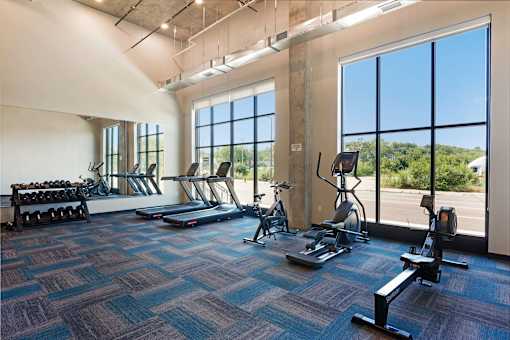 A gym with treadmills, exercise bikes, and dumbbells at Soul Apartments, St. Paul, 55107