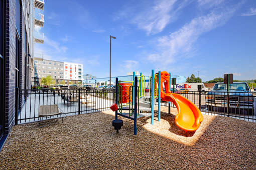 A playground with a slide and a ball on the ground at Soul Apartments, St. Paul, MN