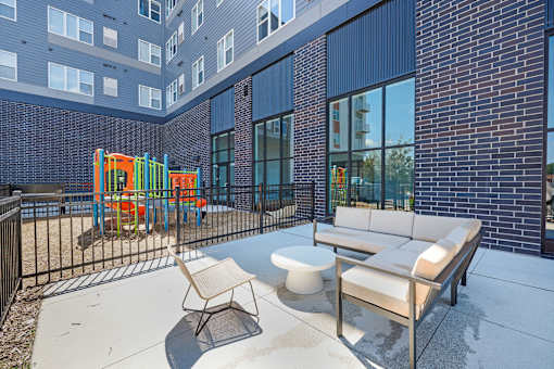 A playground area with a slide and a bench outside a building at Soul Apartments, Minnesota