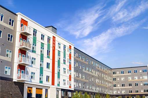 A modern apartment building with balconies and a clear blue sky at Soul Apartments, Minnesota 55107
