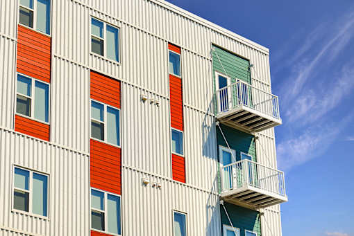 A building with a white facade and red and green accents at Soul Apartments, Minnesota