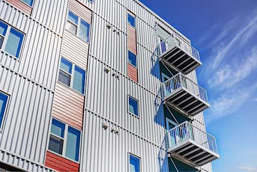 A tall building with a striped facade and blue sky in the background at Soul Apartments, St. Paul, 55107