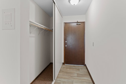 a hallway with a wooden door and a white wall