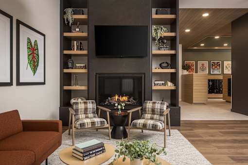 A living room with a fireplace and a television mounted above it.