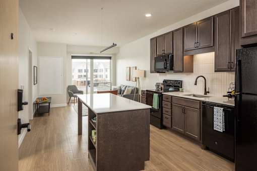 A kitchen with dark brown cabinets and a white island.
