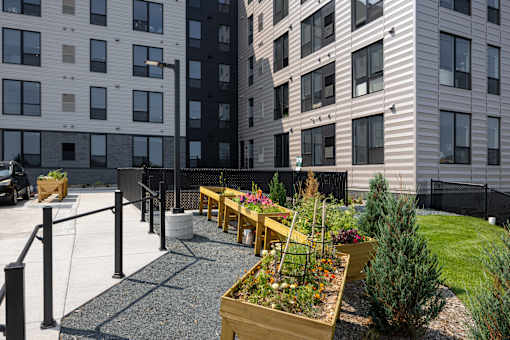 A view of a courtyard with a fence and a planter box.