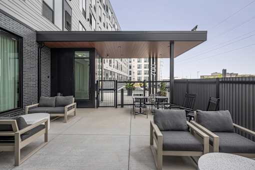 A patio with a table and chairs is in front of a building.