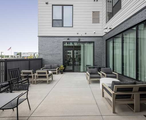 A patio with furniture and a building in the background.