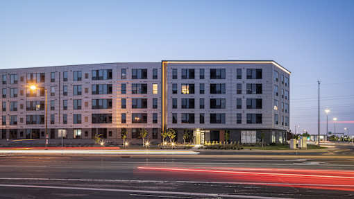A modern building with a parking lot in front of it.