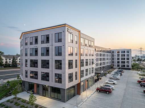 A modern building with a parking lot in front.