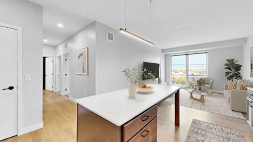 A modern kitchen with a large island and wooden cabinets.at The Rosalyn | Affordable 55+ Apartments in Bloomington, Bloominton Minnesota