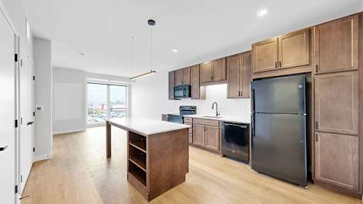 A kitchen with wooden cabinets and a refrigerator.